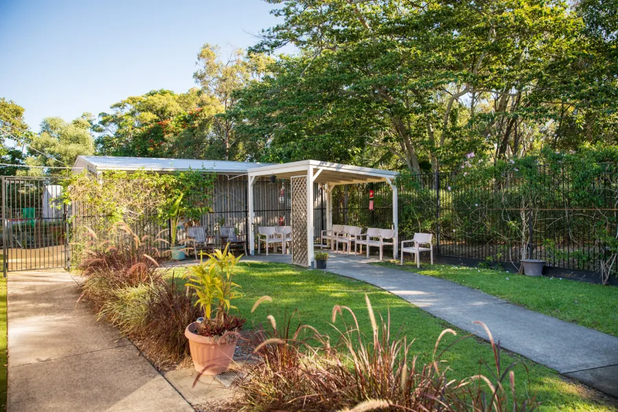 Garden paths and covered outdoor seating at Caloundra Place Care Community.